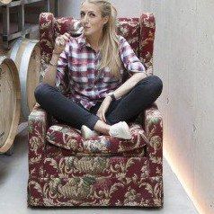 Doris Frühwirth, sitzend in einem Fauteuil im Fasskeller des Weinguts