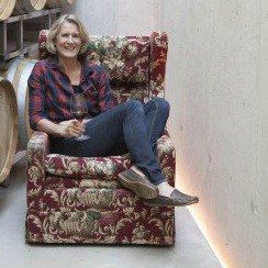 Gerlinde Frühwirth, sitzend in einem Fauteuil im Fasskeller des Weinguts