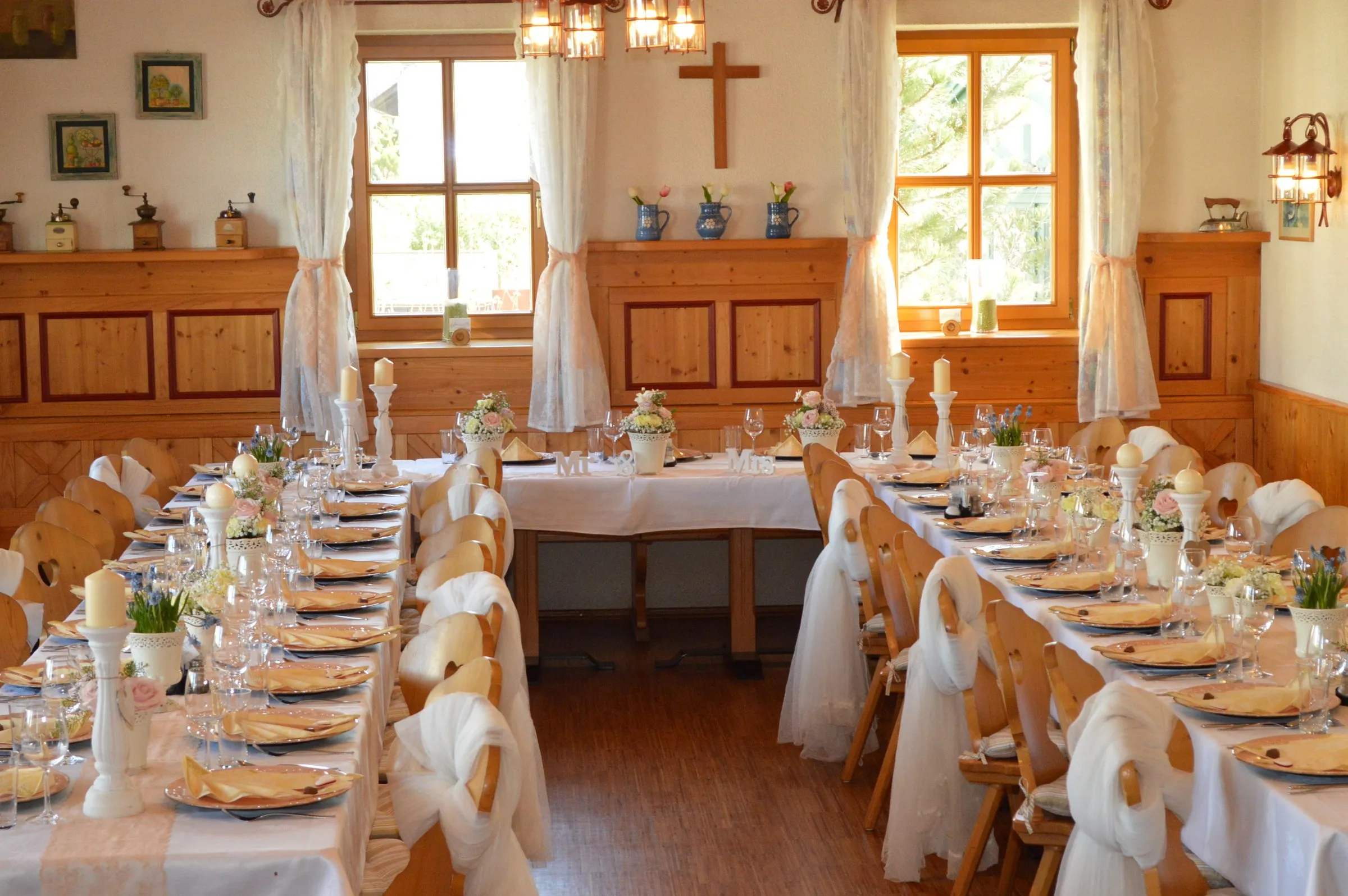 Erkerraum mit Fensterfront zum Garten, festlich gedeckte Tafel unter heller Holzdecke