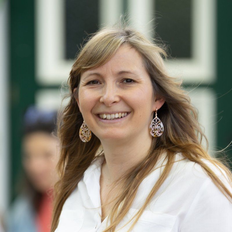 Tamara Frühwirth lächelnd im Gastgarten des Heurigen